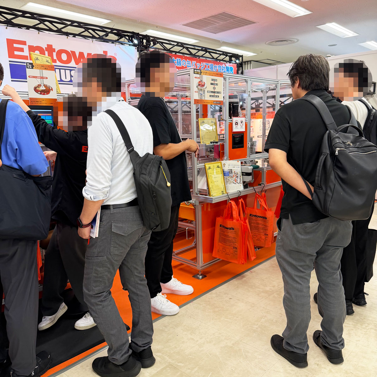 エントワーズブースで機械を見る来場者